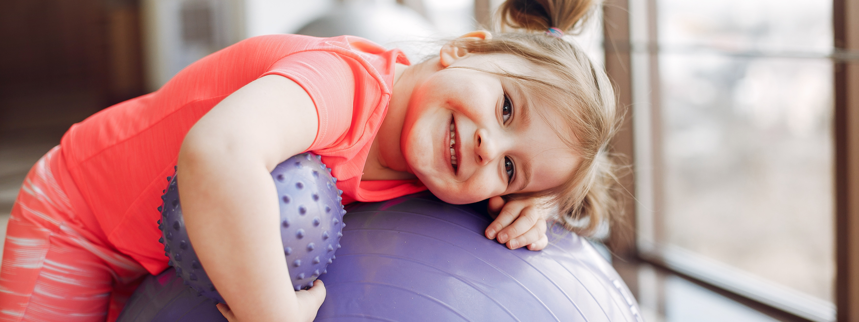 Niña pequeña con pelotas de goma