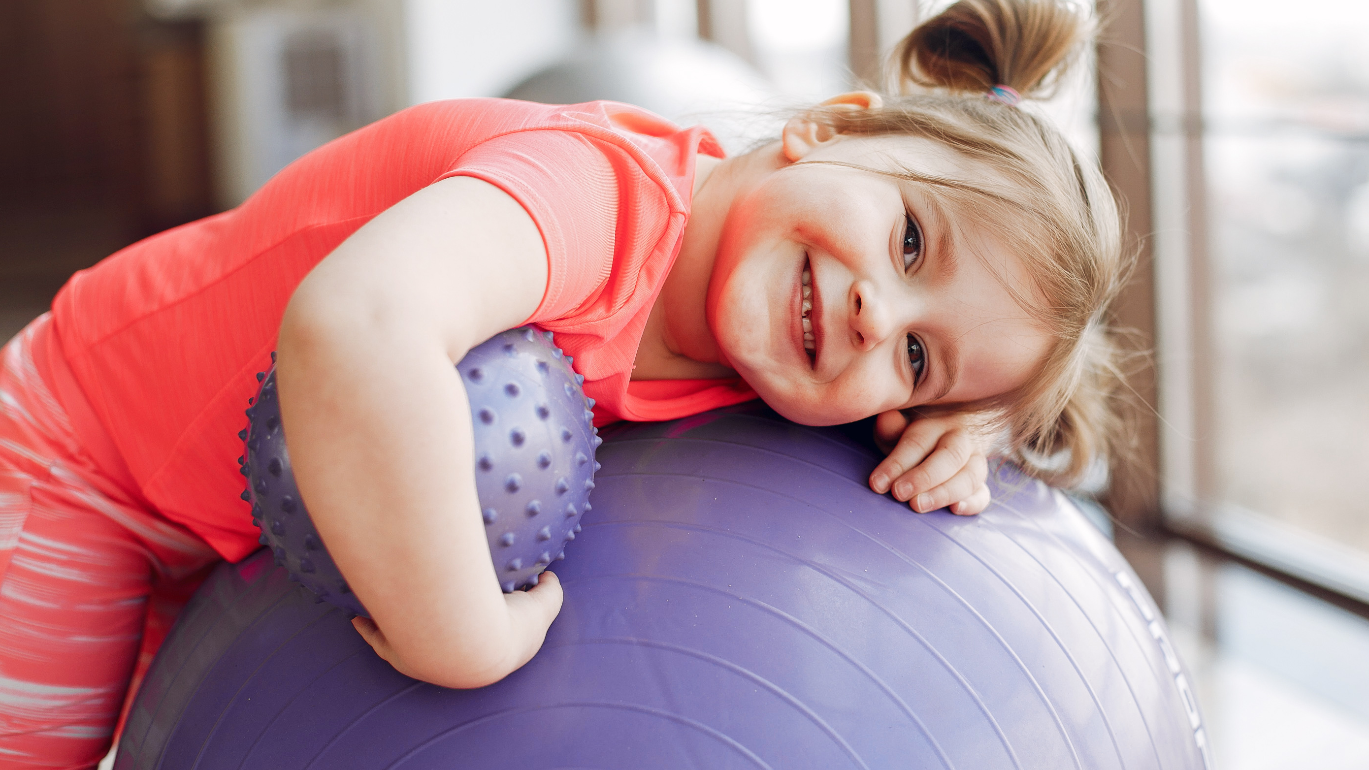 Niña pequeña con pelotas de goma