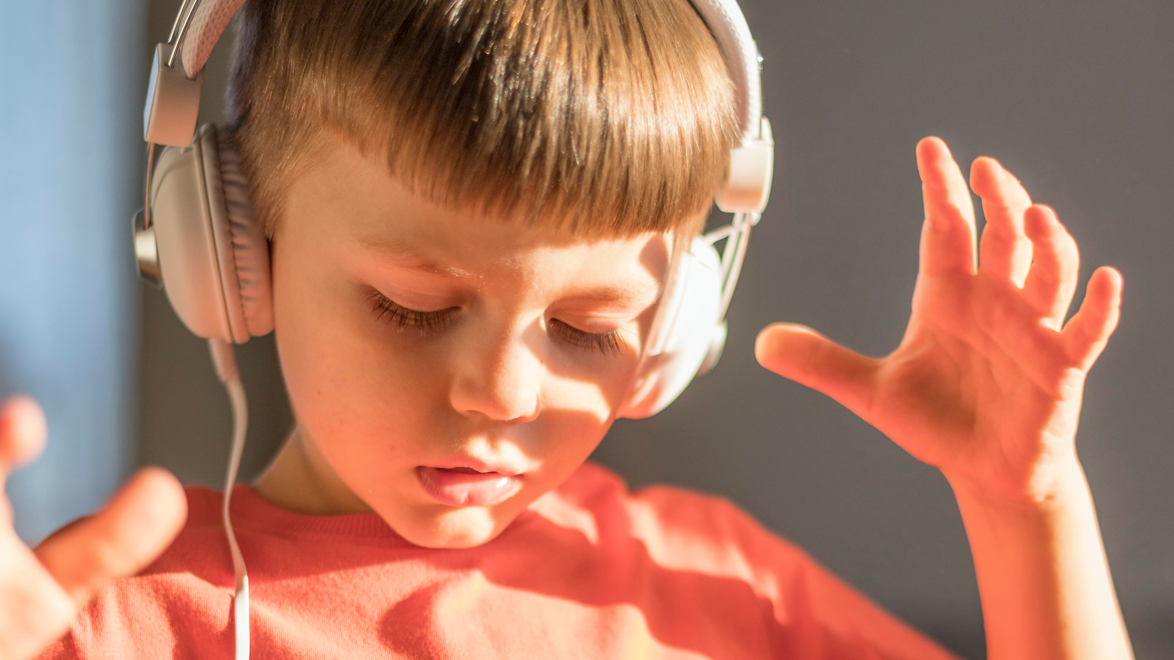 Niño oyendo a través de auriculares