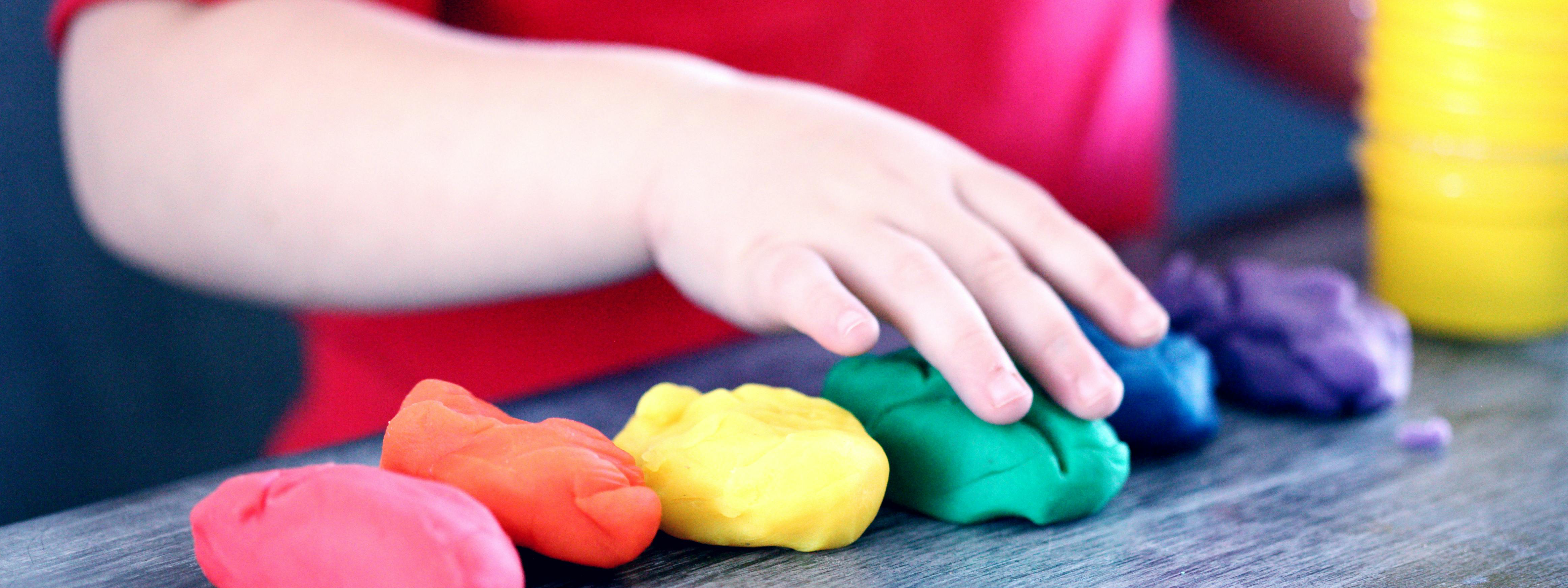 Manos de un niño jugando con plastilina