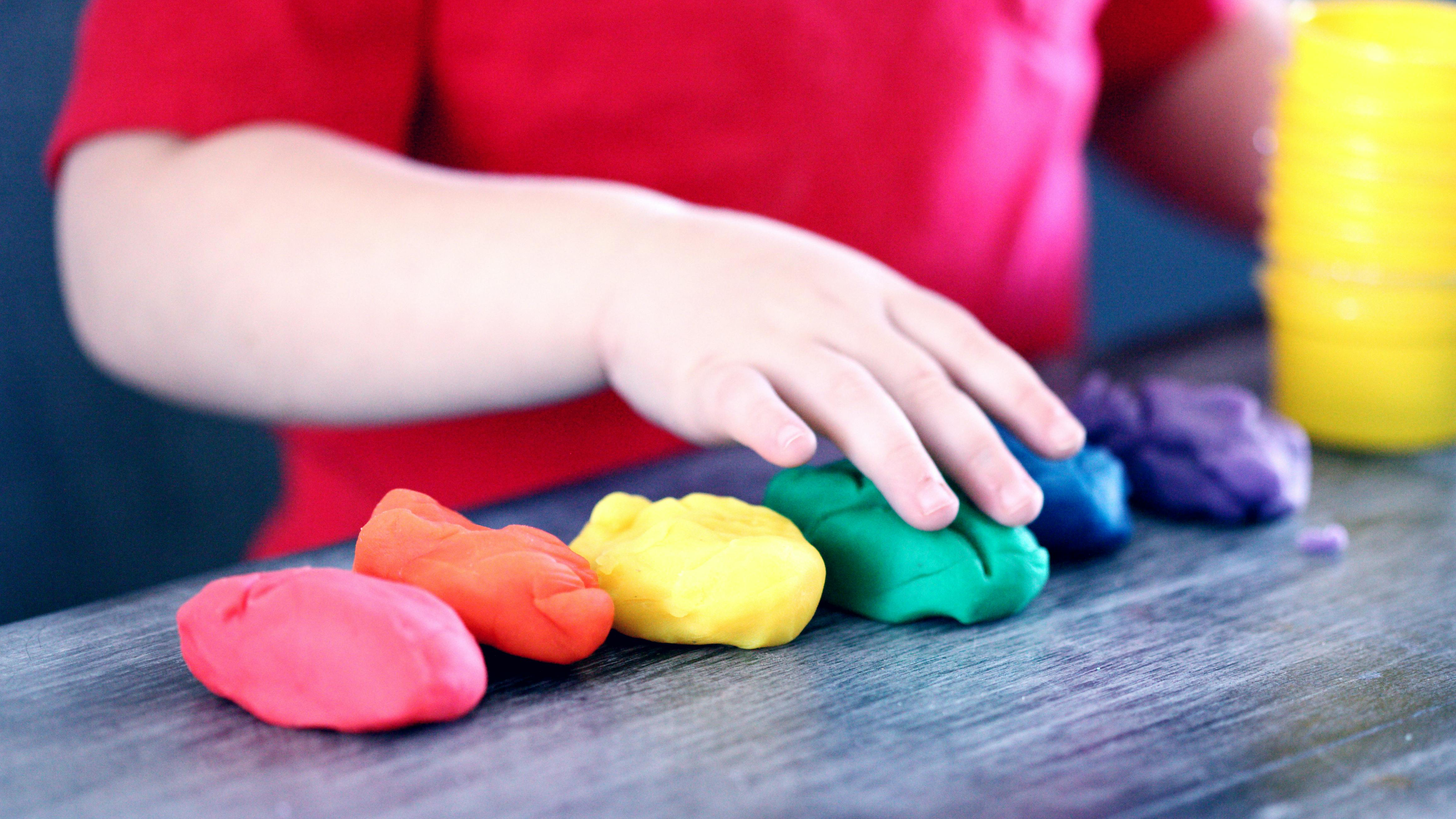 Manos de un niño jugando con plastilina